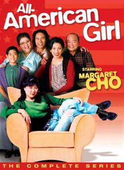 A multi-generational family of six Asians gather at a chair