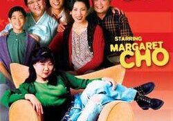 A multi-generational family of six Asians gather at a chair