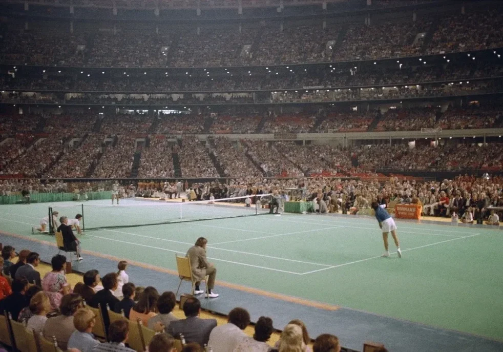 Indoor tennis game with audience watching